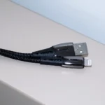 دو سر کابل لایتنینگ کینگ استار K360i با سوکت فلزی روی پس‌زمینه چوبی